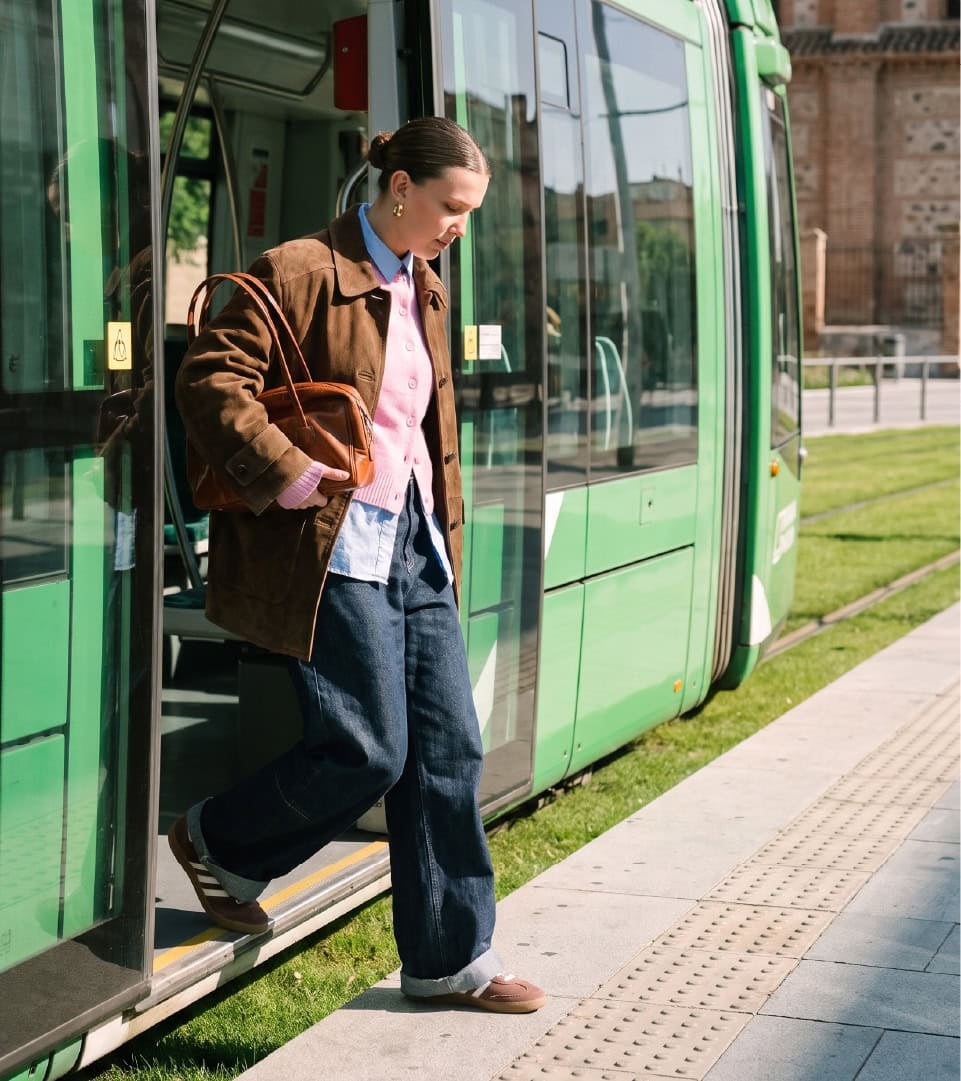 Viajera bajando del Tranvía de Parla en una parada con césped, caso de Baud